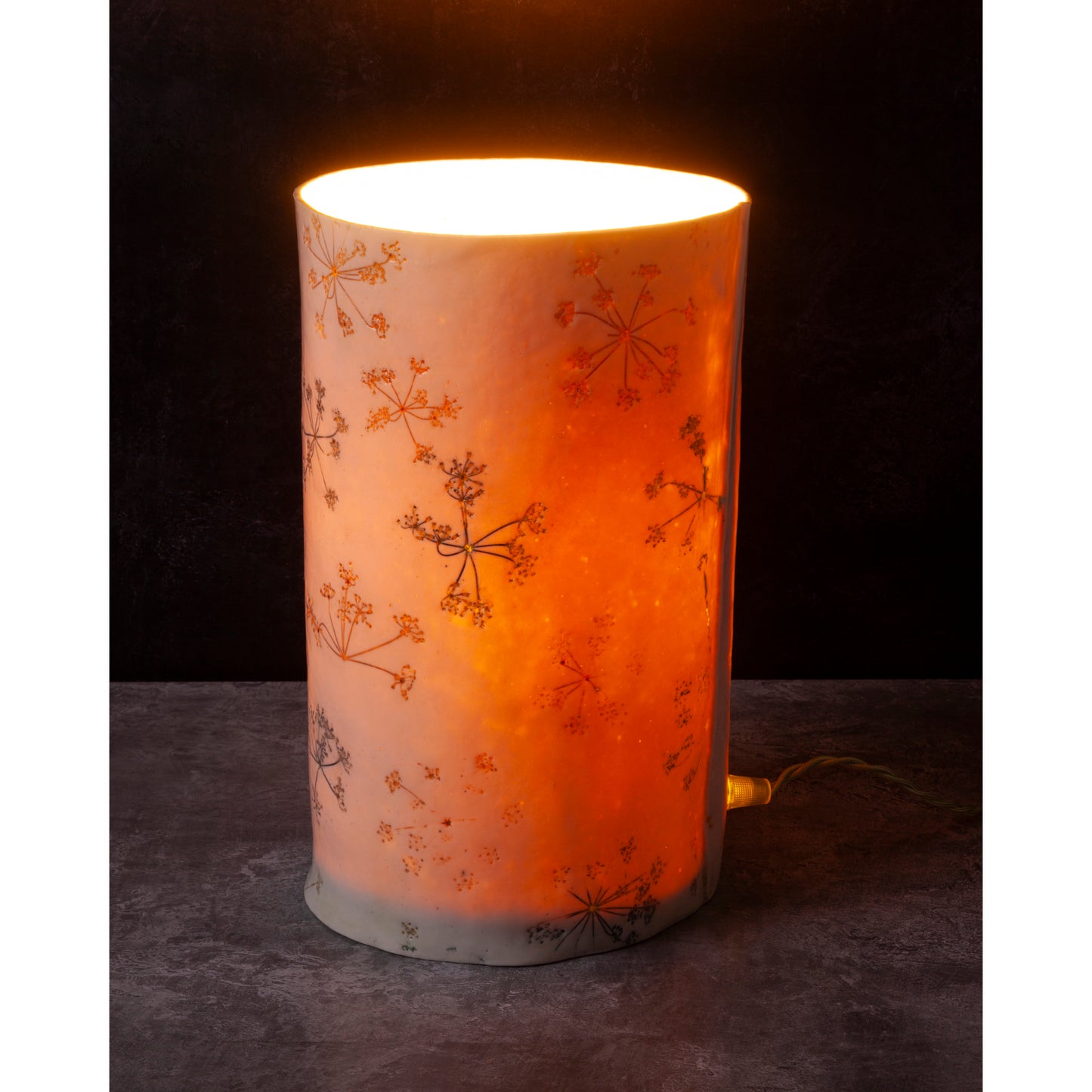 porcelain Cylindrical lamp with floral patterns on a dark background