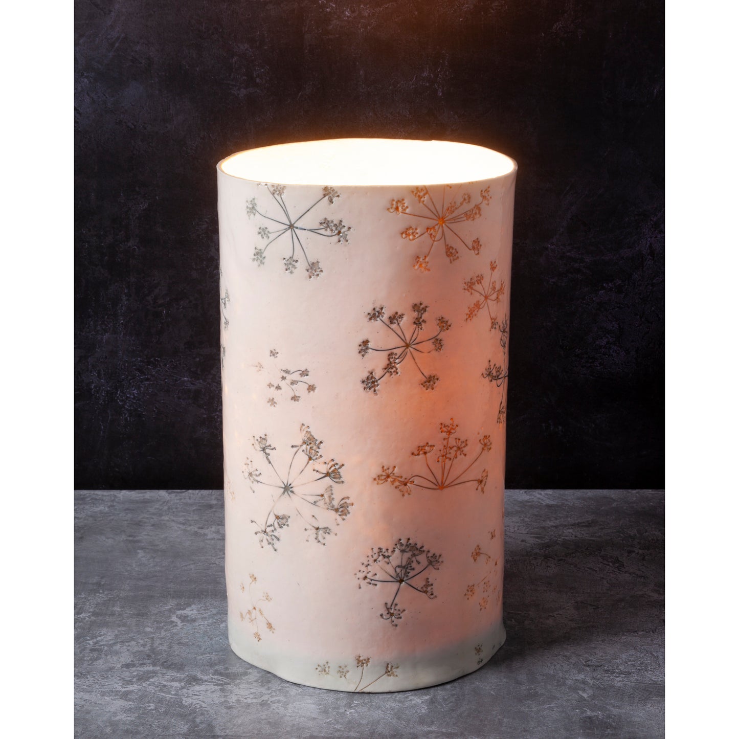 Decorative porcelain lamp with floral patterns on a dark background
