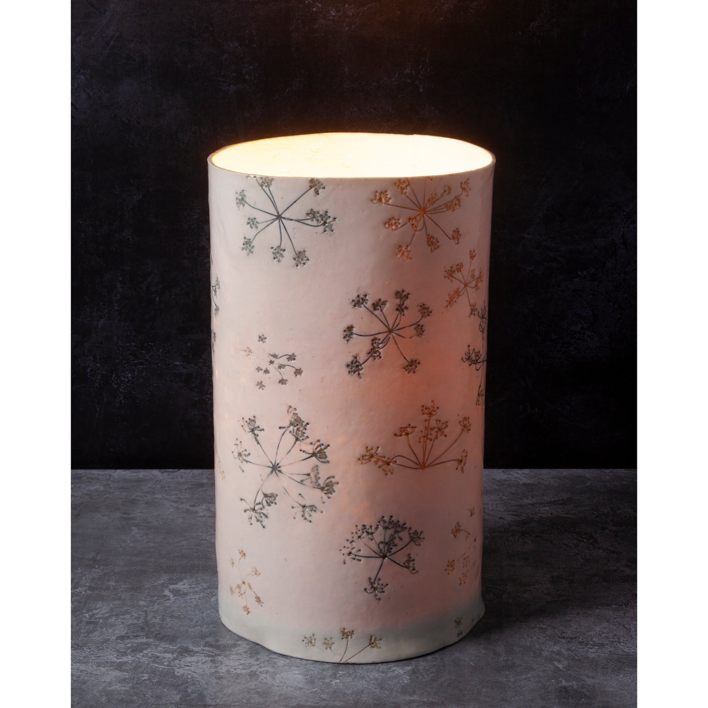 Cylindrical lamp with floral pattern on a dark background