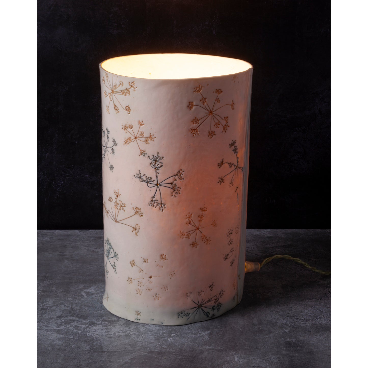 Cylindrical lamp with floral pattern on a dark background
