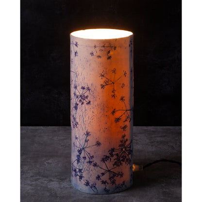 Porcelain lamp impressed with Queen Anne's Lace flowers. Photographed against a dark background