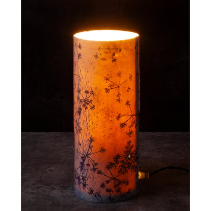 Porcelain lamp impressed with Queen Anne's Lace flowers. Photographed against a dark background