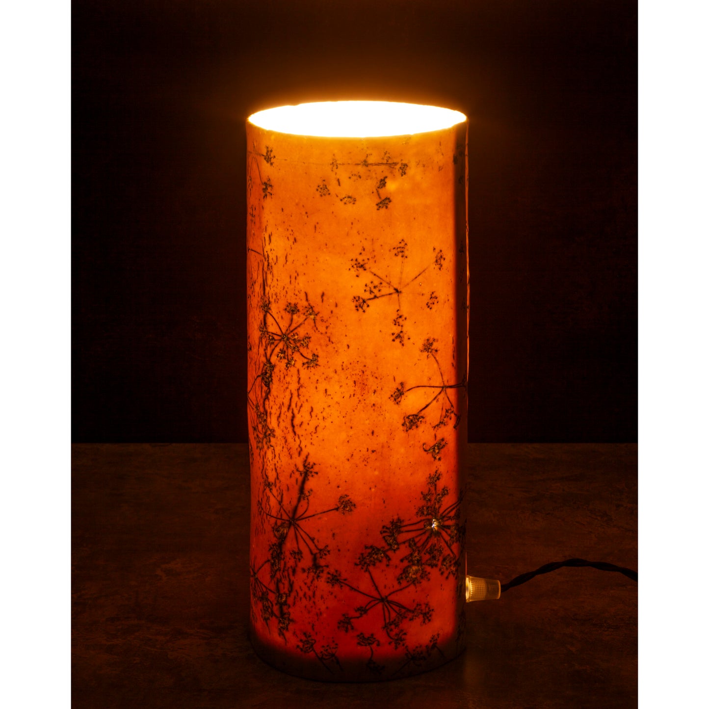 Porcelain lamp impressed with Queen Anne's Lace flowers. Photographed against a dark background