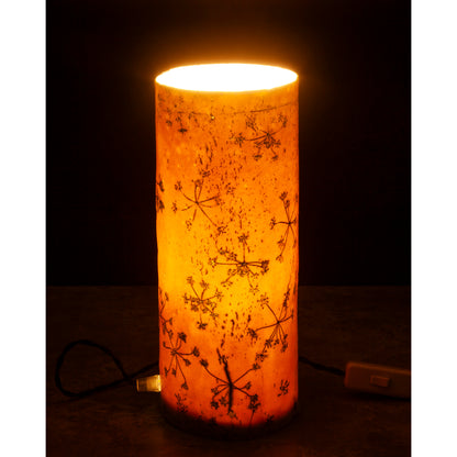 Porcelain lamp impressed with Queen Anne's Lace flowers. Photographed against a dark background