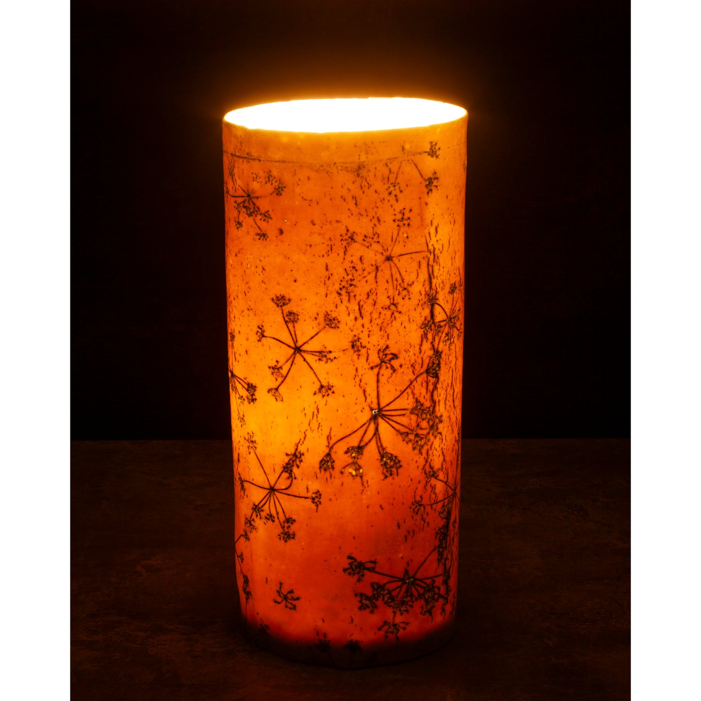 Porcelain lamp impressed with Queen Anne's Lace flowers. Photographed against a dark background