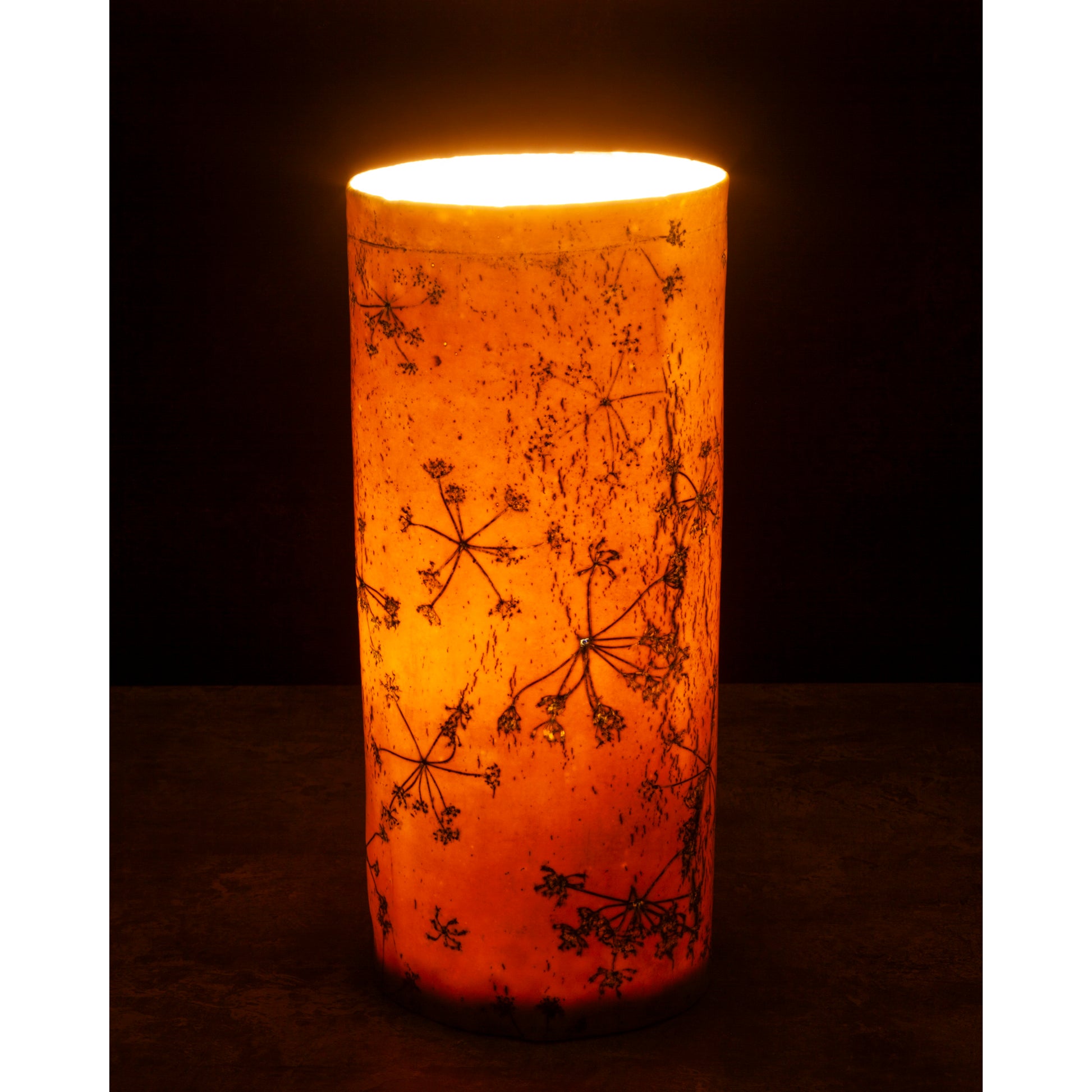 Porcelain lamp impressed with Queen Anne's Lace flowers. Photographed against a dark background