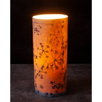 Porcelain lamp impressed with Queen Anne's Lace flowers. Photographed against a dark background