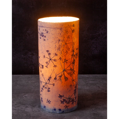 Porcelain lamp impressed with Queen Anne's Lace flowers. Photographed against a dark background