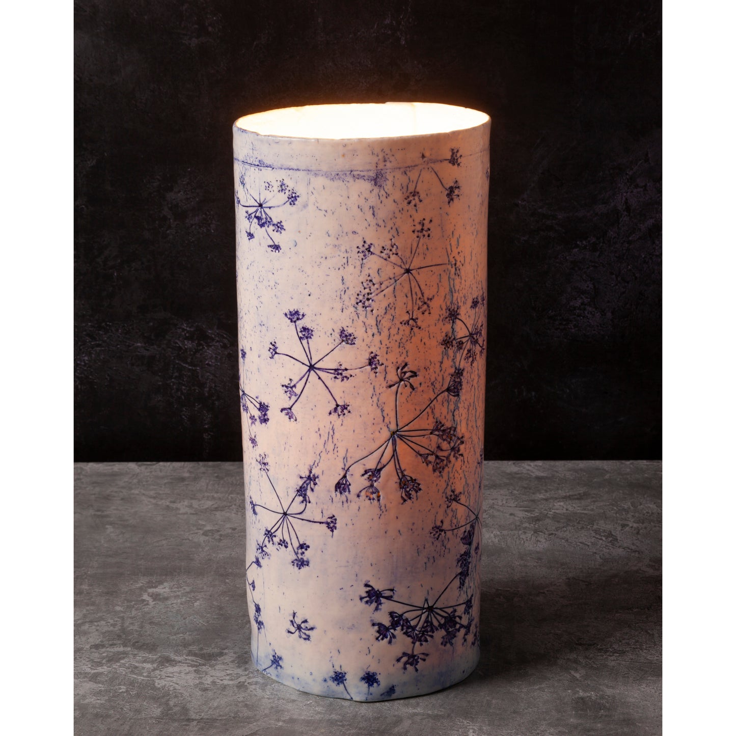 Porcelain lamp impressed with Queen Anne's Lace flowers. Photographed against a dark background