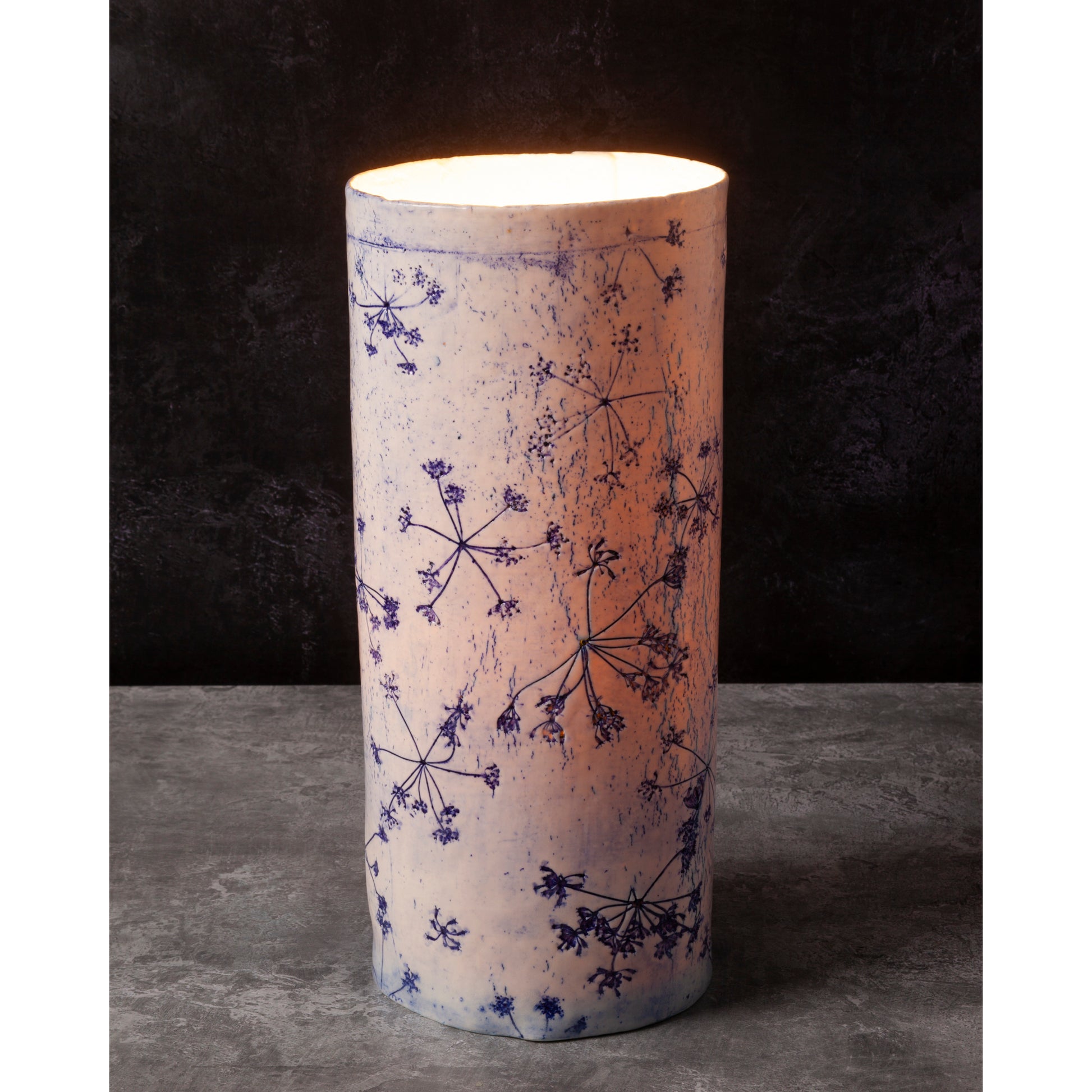 Porcelain lamp impressed with Queen Anne's Lace flowers. Photographed against a dark background