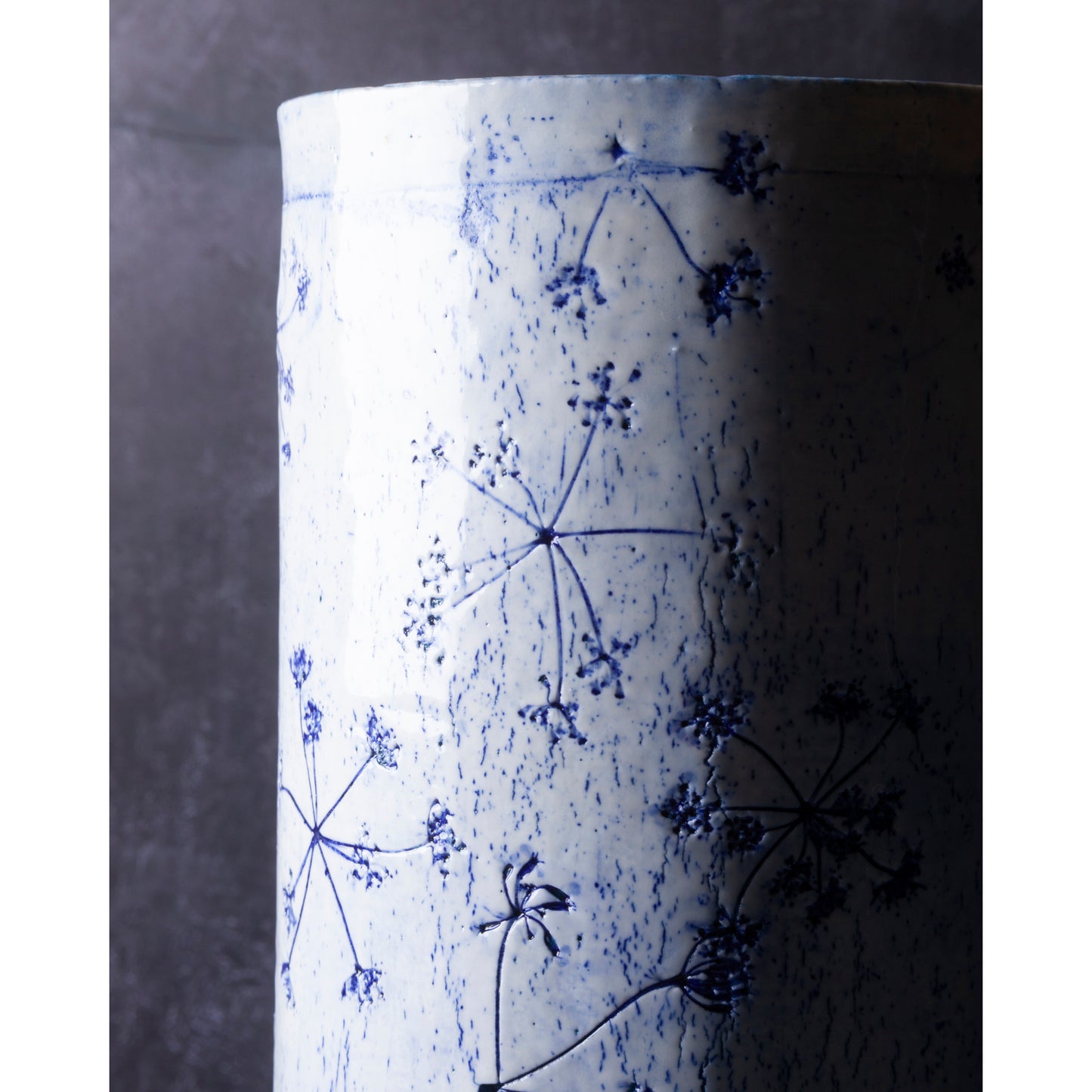 Detail of Porcelain lamp impressed with Queen Anne's Lace flowers. Photographed against a dark background