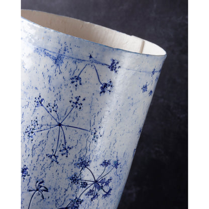 Detail of Porcelain lamp impressed with Queen Anne's Lace flowers. Photographed against a dark background