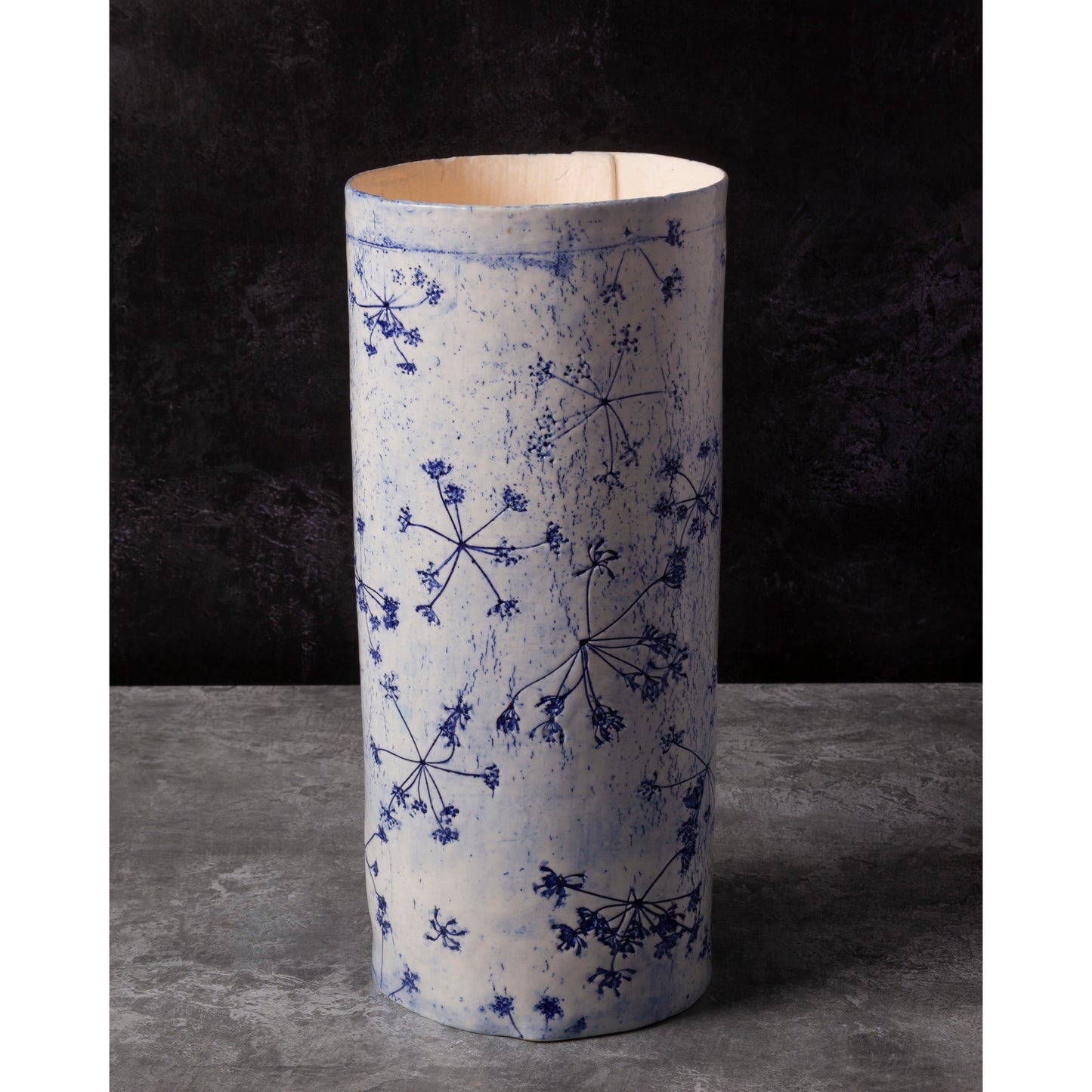 Porcelain lamp impressed with Queen Anne's Lace flowers. Photographed against a dark background