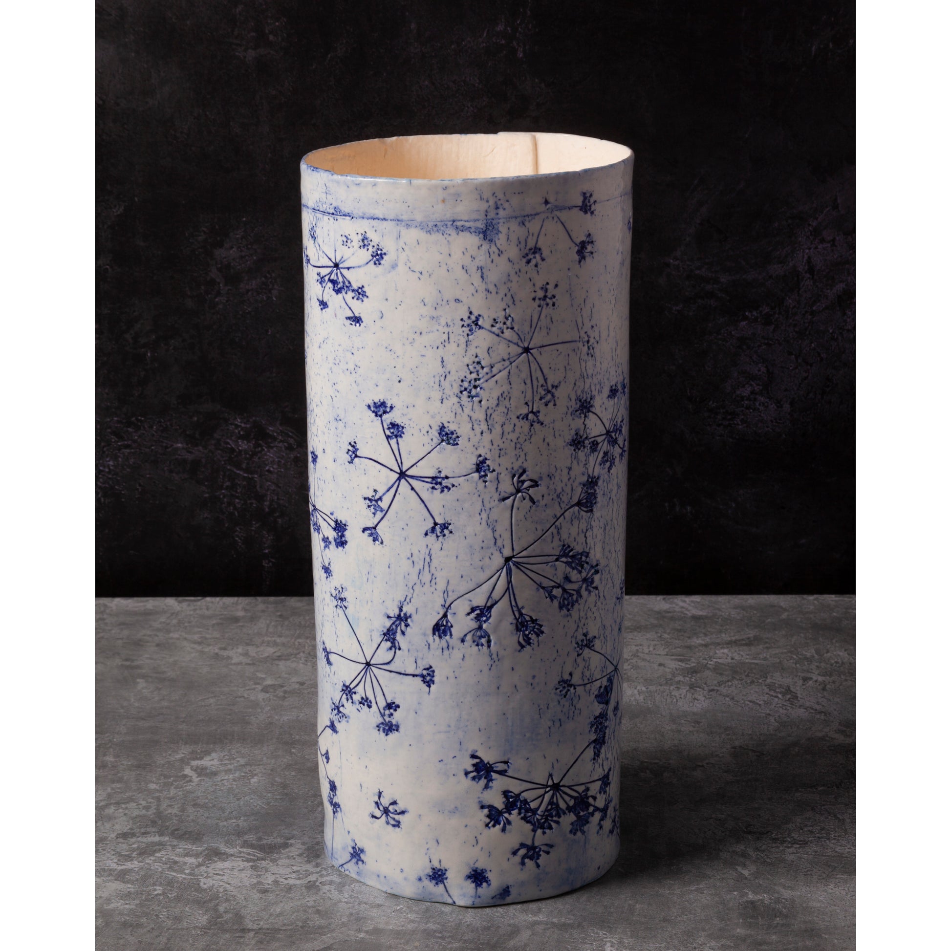 Porcelain lamp impressed with Queen Anne's Lace flowers. Photographed against a dark background