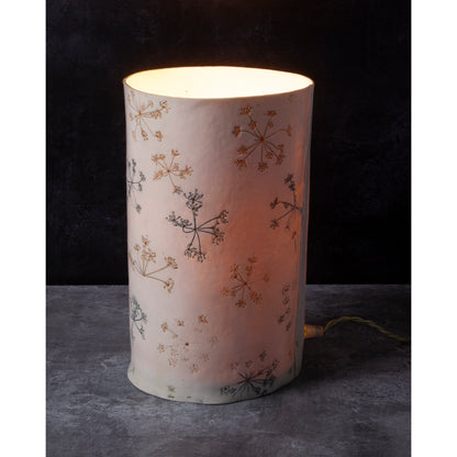 Cylindrical lamp with floral pattern on a dark background