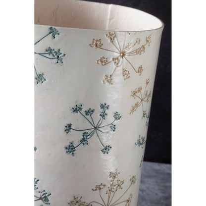 Detail of cylindrical lamp with floral pattern, queen anne's lace, on a white background. unlit