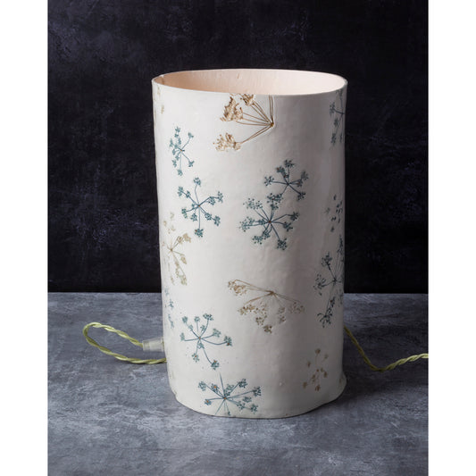 Cylindrical lamp with floral pattern on a dark background