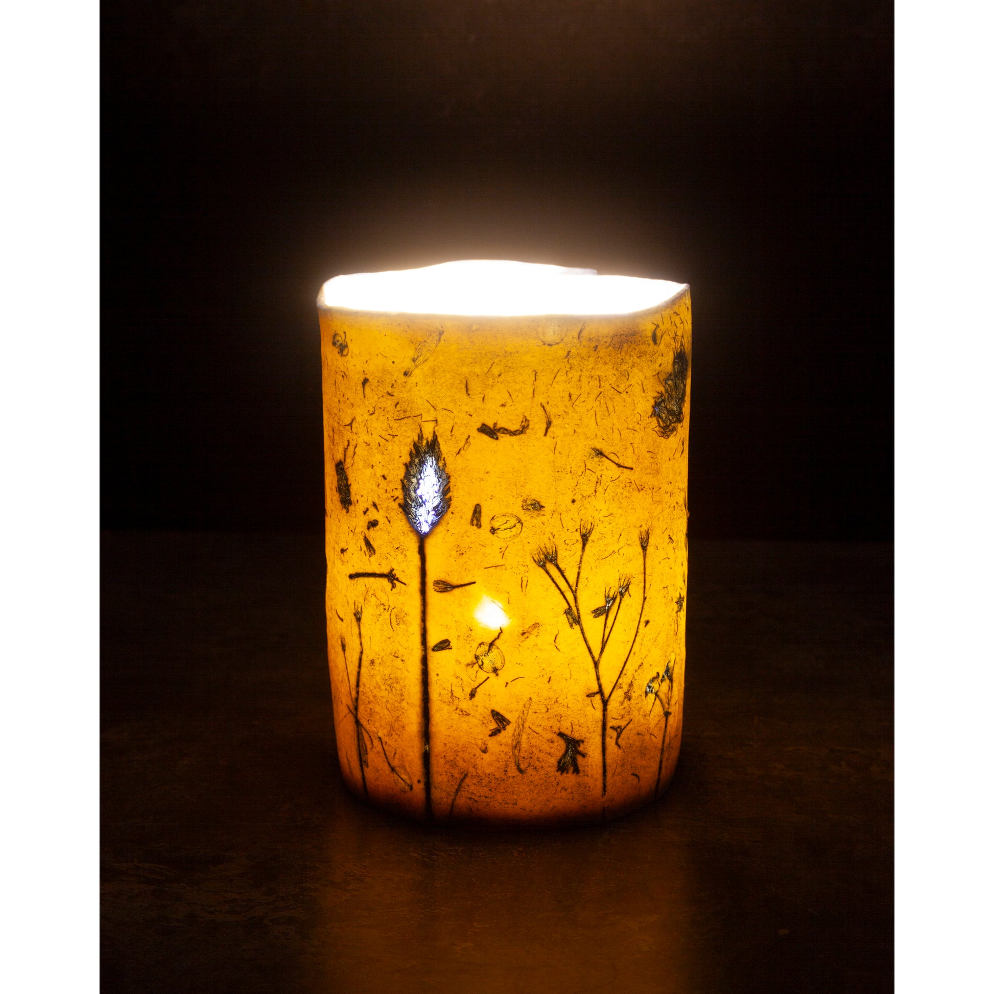 Decorative candle holder with floral patterns on a dark background