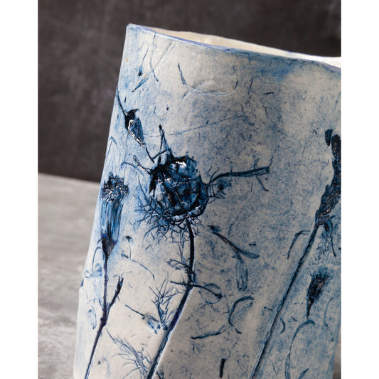 Ceramic vase with blue floral patterns on a neutral background