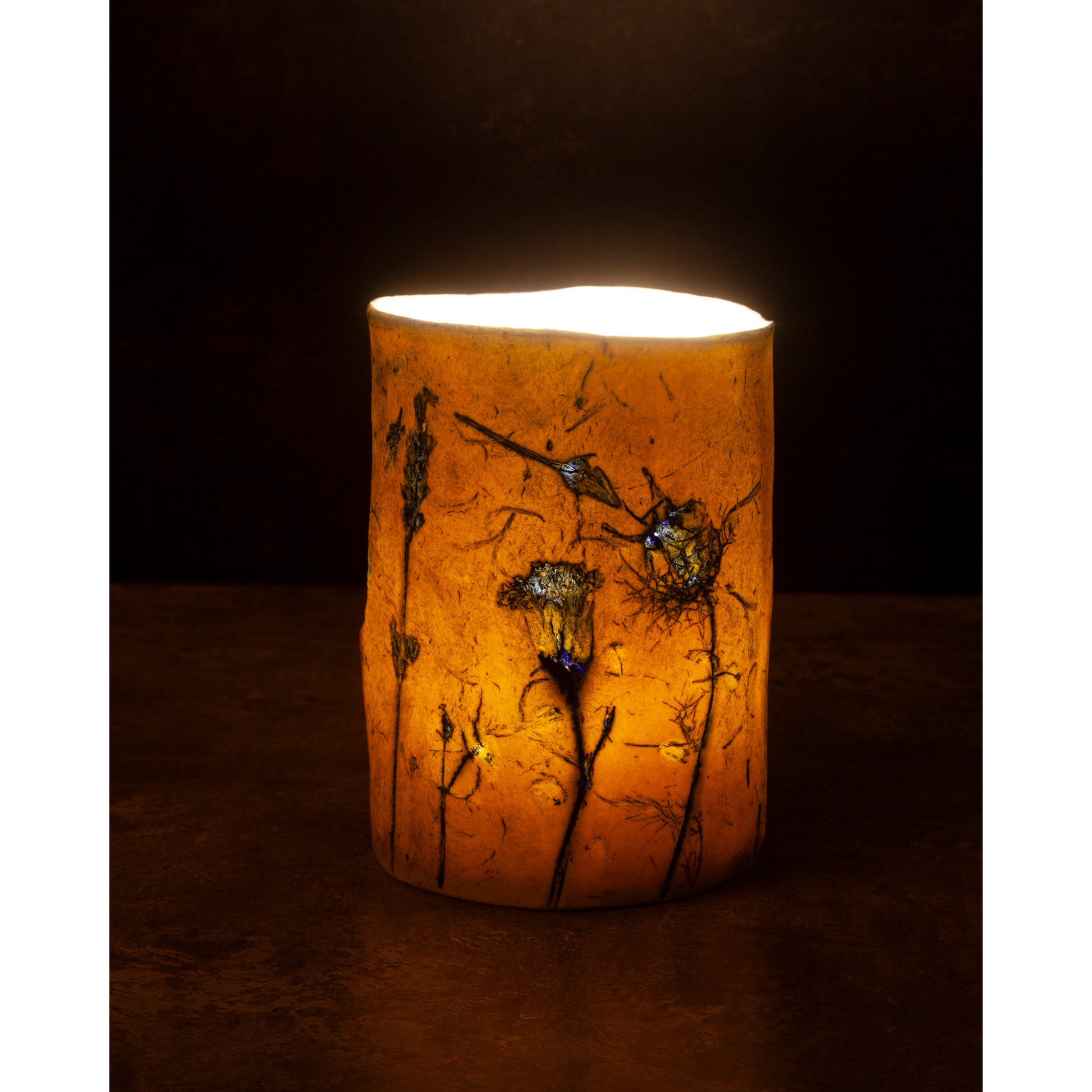 Decorative candle holder with floral design on a dark background