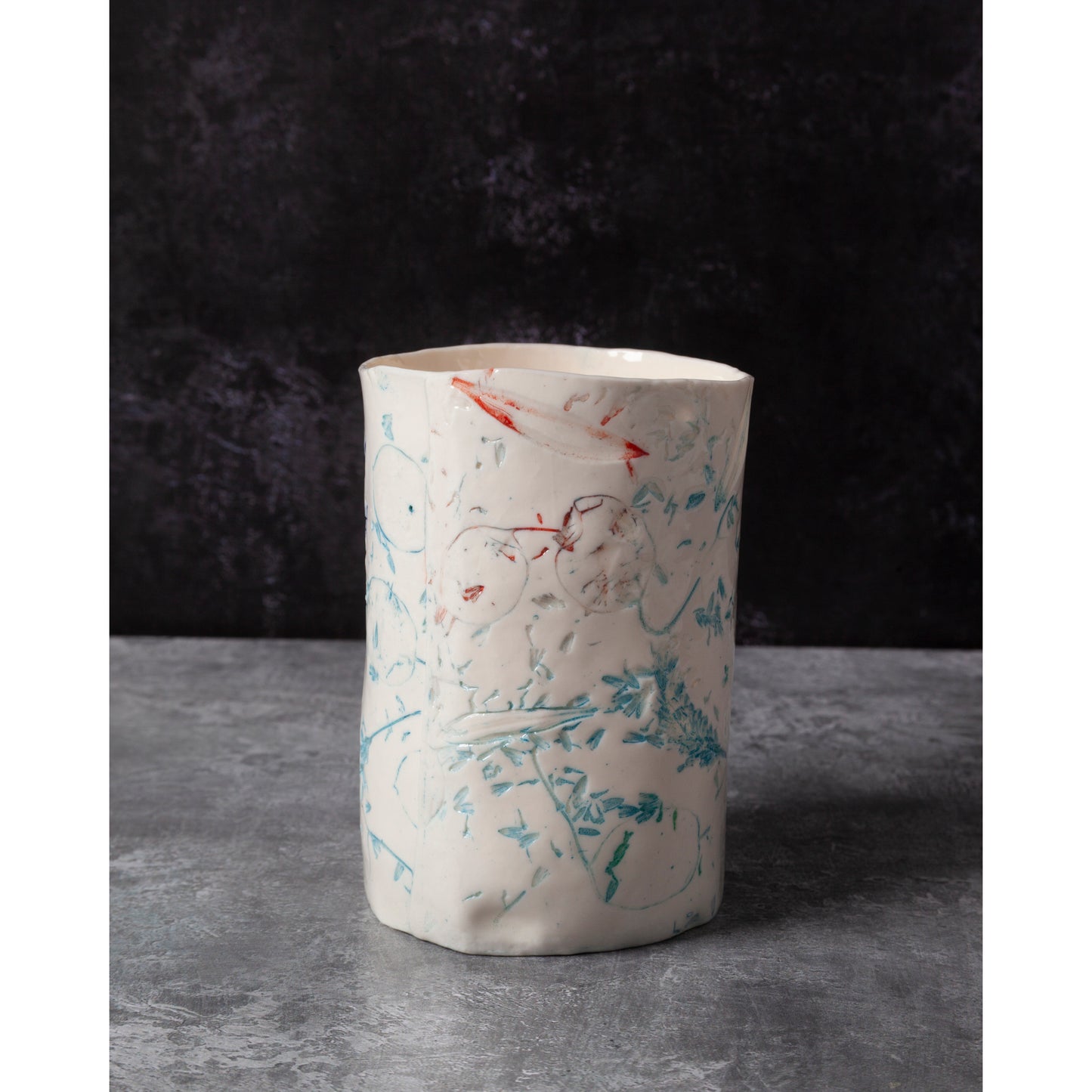 Cylindrical porcelain ceramic vase with abstract designs  using honesty seed heads, lavender, grasses and olive leaves in a dark background
