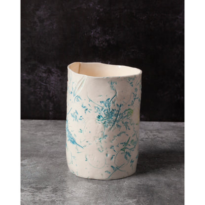 Cylindrical porcelain ceramic vase with abstract designs  using honesty seed heads, lavender, grasses and olive leaves photographed in a dark background