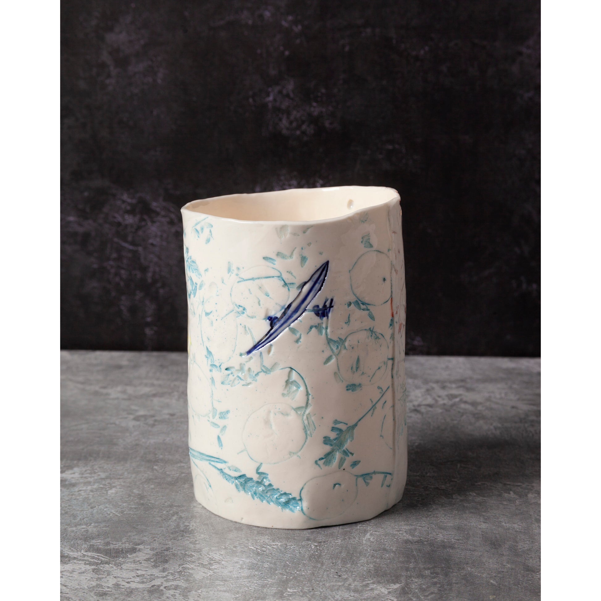 Ceramic vase with blue abstract designs on a dark background