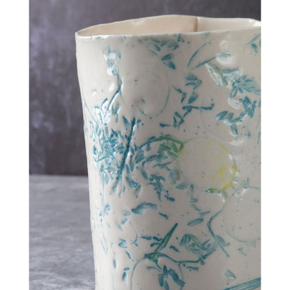 White ceramic vase with blue floral patterns on a gray background