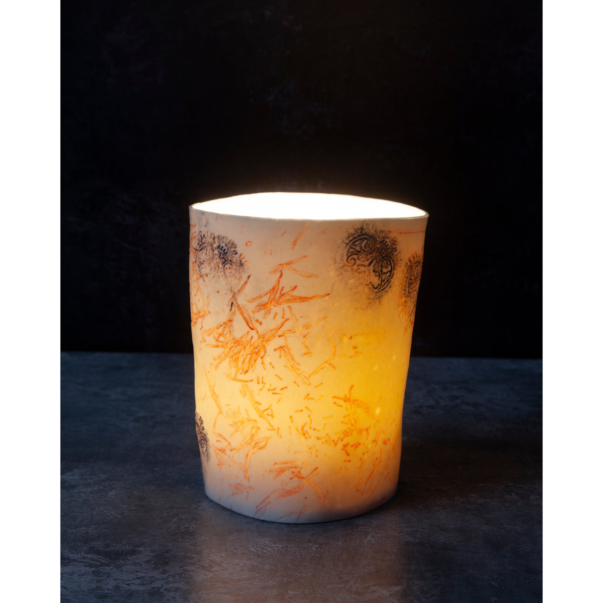 Decorative tealight candle / vase with a textured surface. Photographed on a dark background