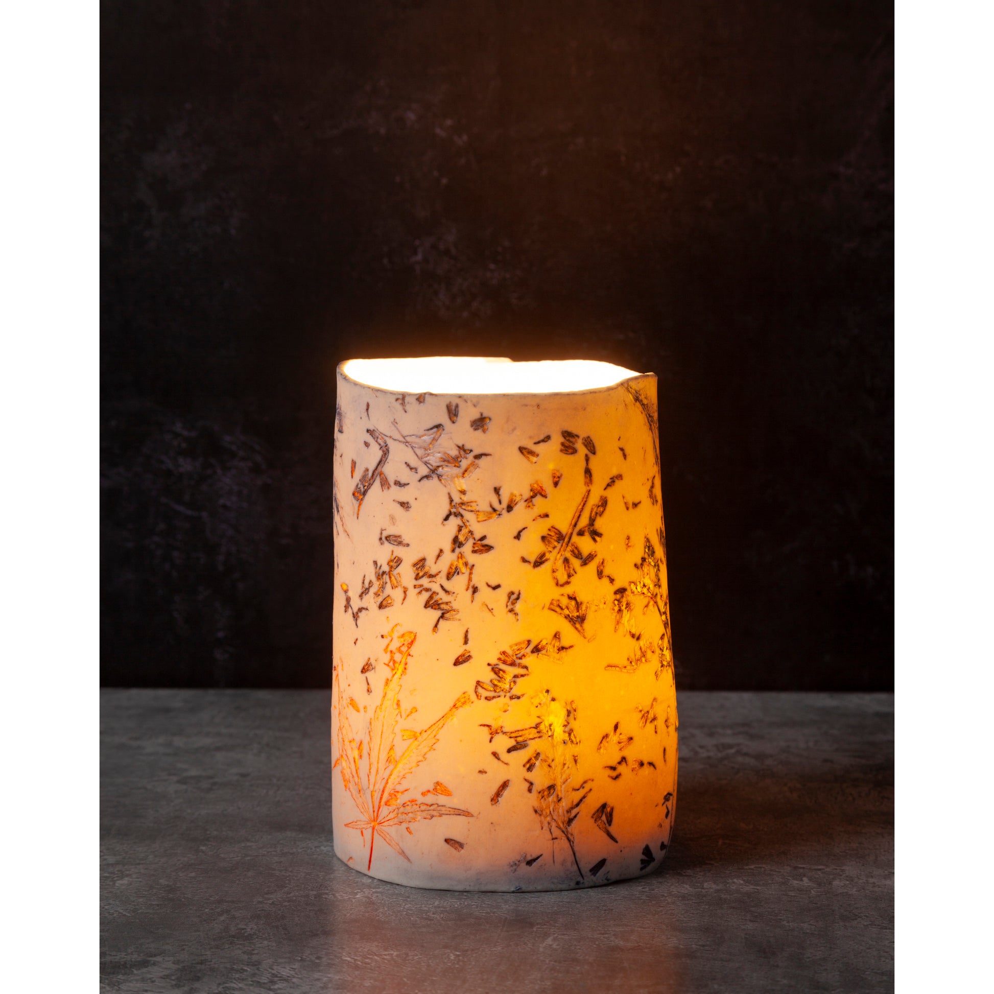 Ceramic night light / vase with lavender, grasses and leaf patterns on a white porcelain surface. High lights of blue and orange