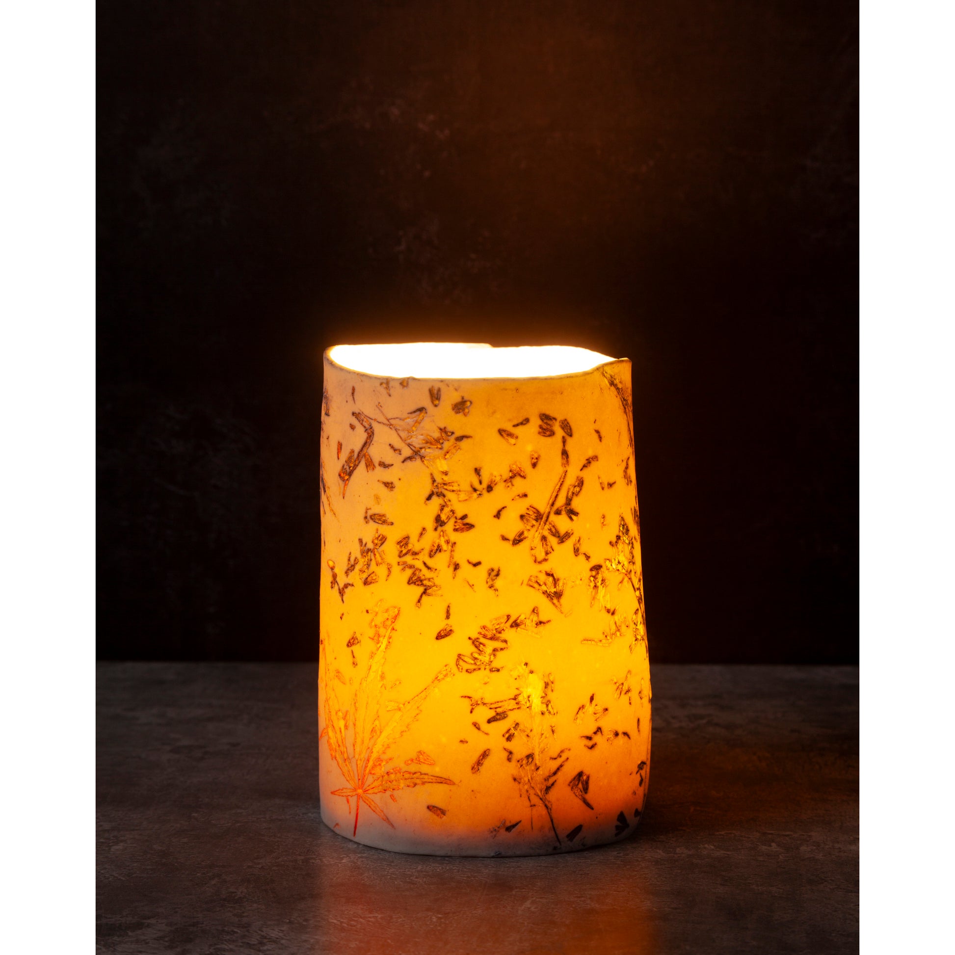 Ceramic night light / vase with lavender, grasses and leaf patterns on a white porcelain surface. High lights of blue and orange