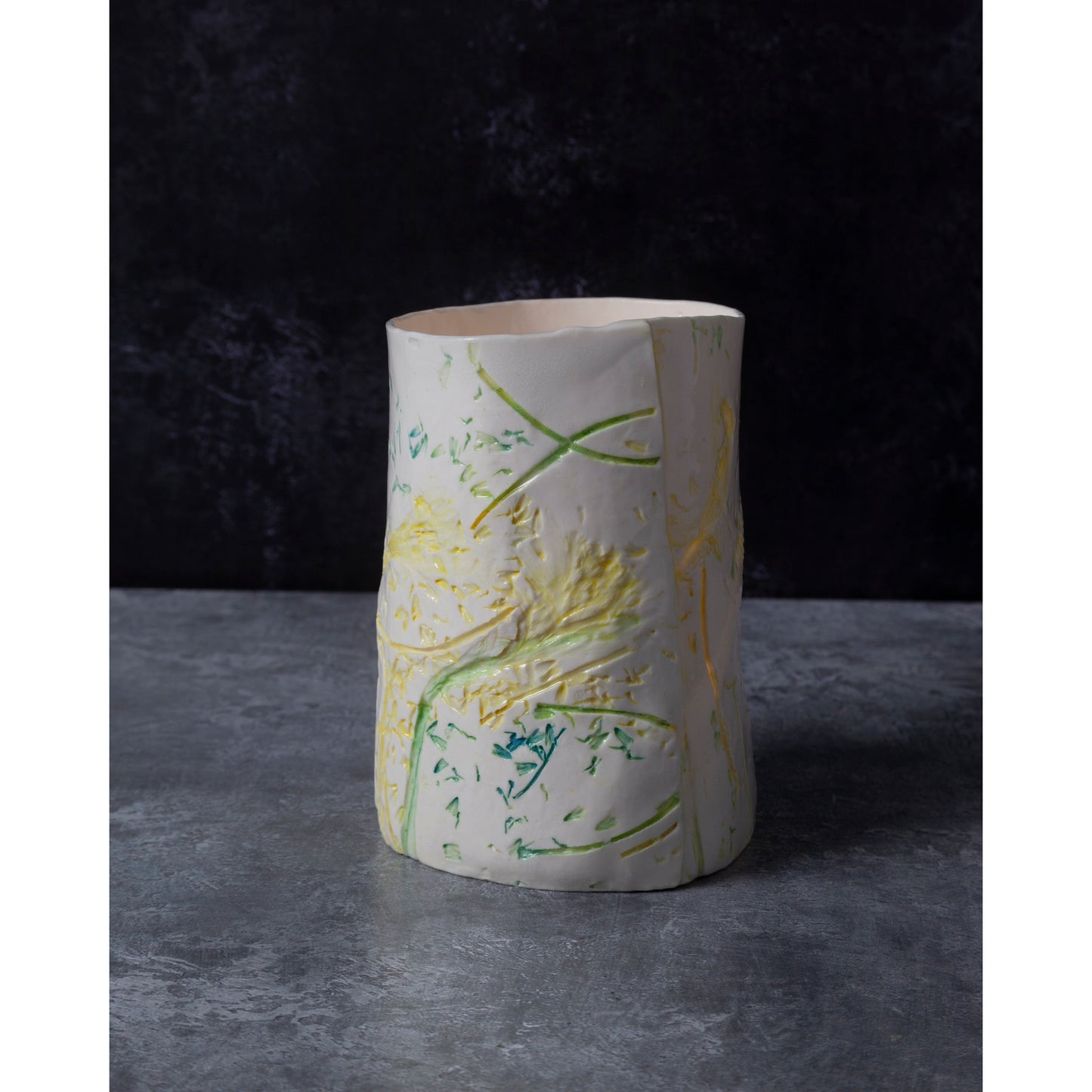 Ceramic vase / night light with green and yellow abstract patterns on a dark background