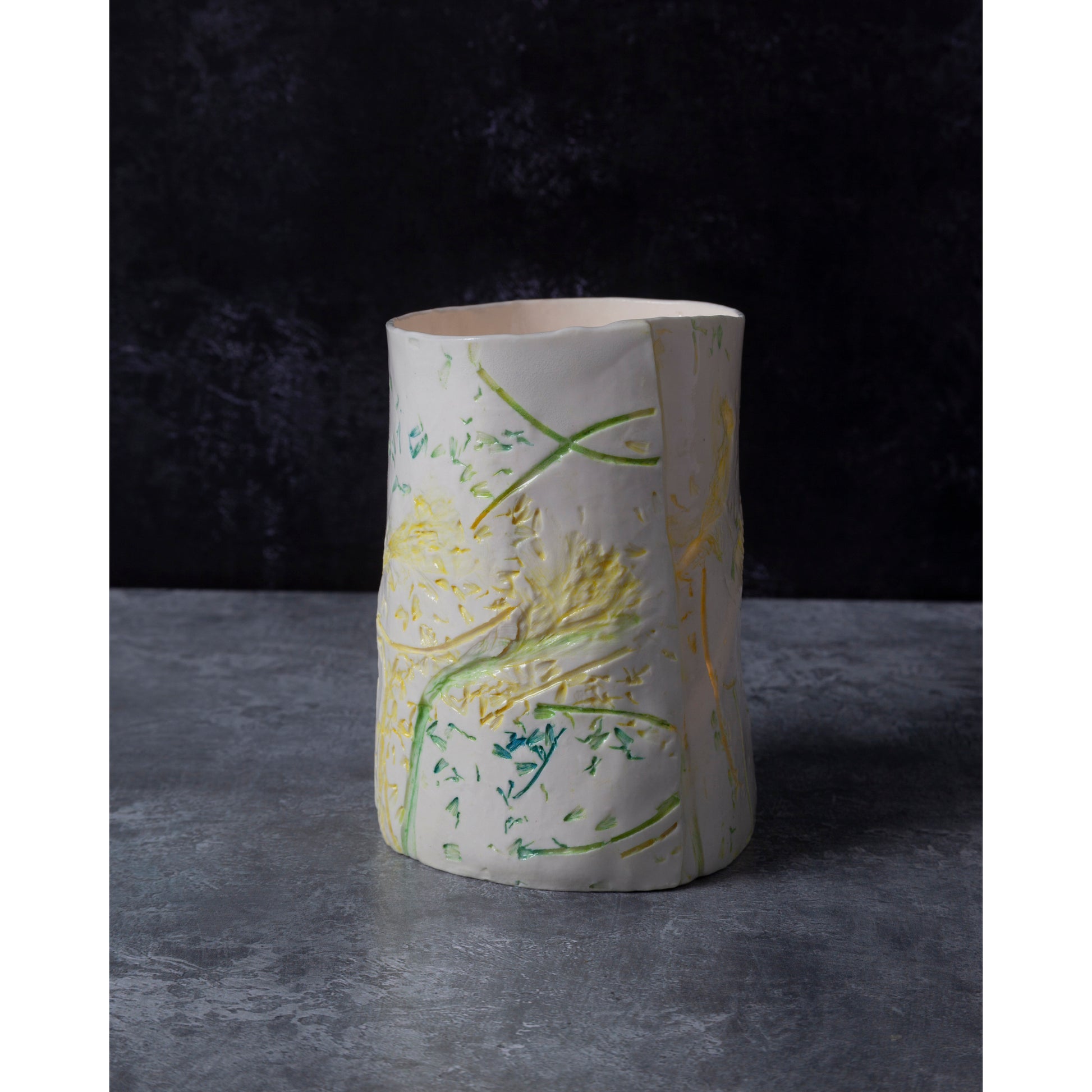 Ceramic vase / night light with green and yellow abstract patterns on a dark background
