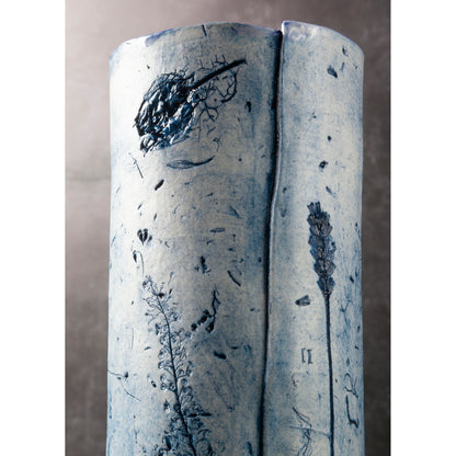 Cylindrical ceramic vase with floral patterns on a plain background