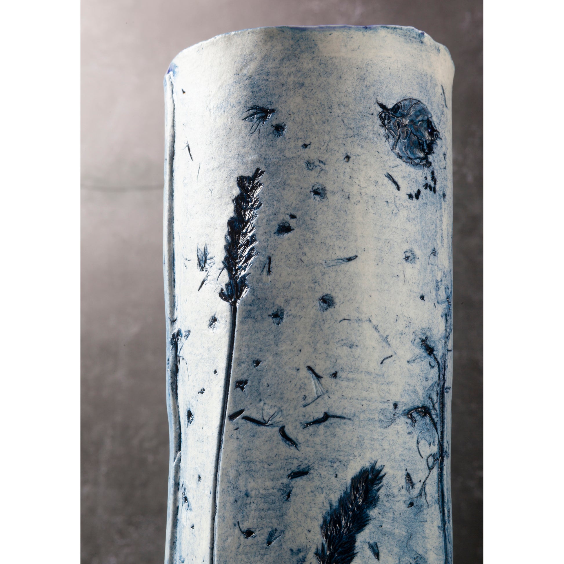 Cylindrical vase with floral pattern on a gray background