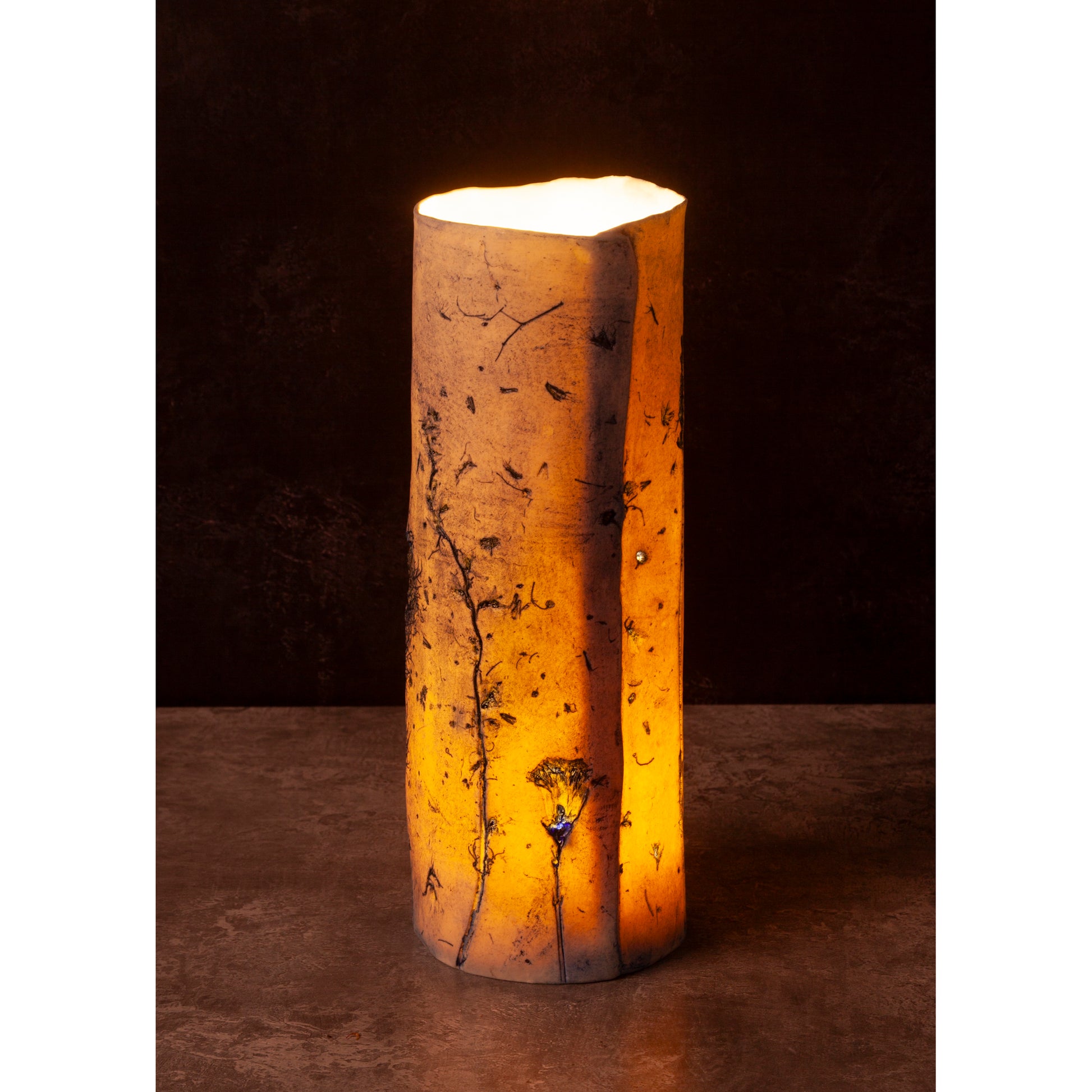 Porcelain night light vase with a warm glow on a dark background