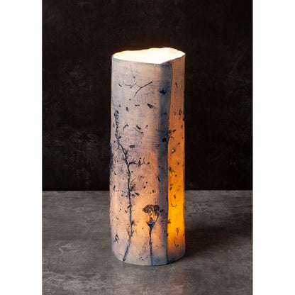 Cylindrical porcelain vessel with natural pattern on a dark background