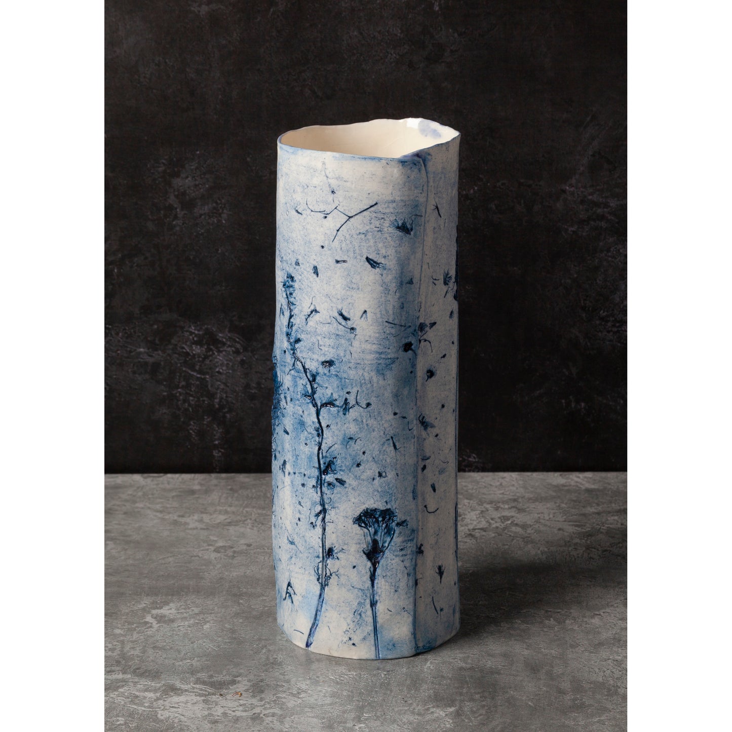 Cylindrical porcelain vase with blue abstract patterns on a dark background