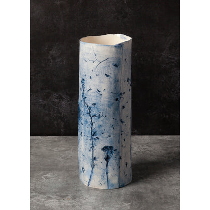 Cylindrical porcelain vase with blue abstract patterns on a dark background