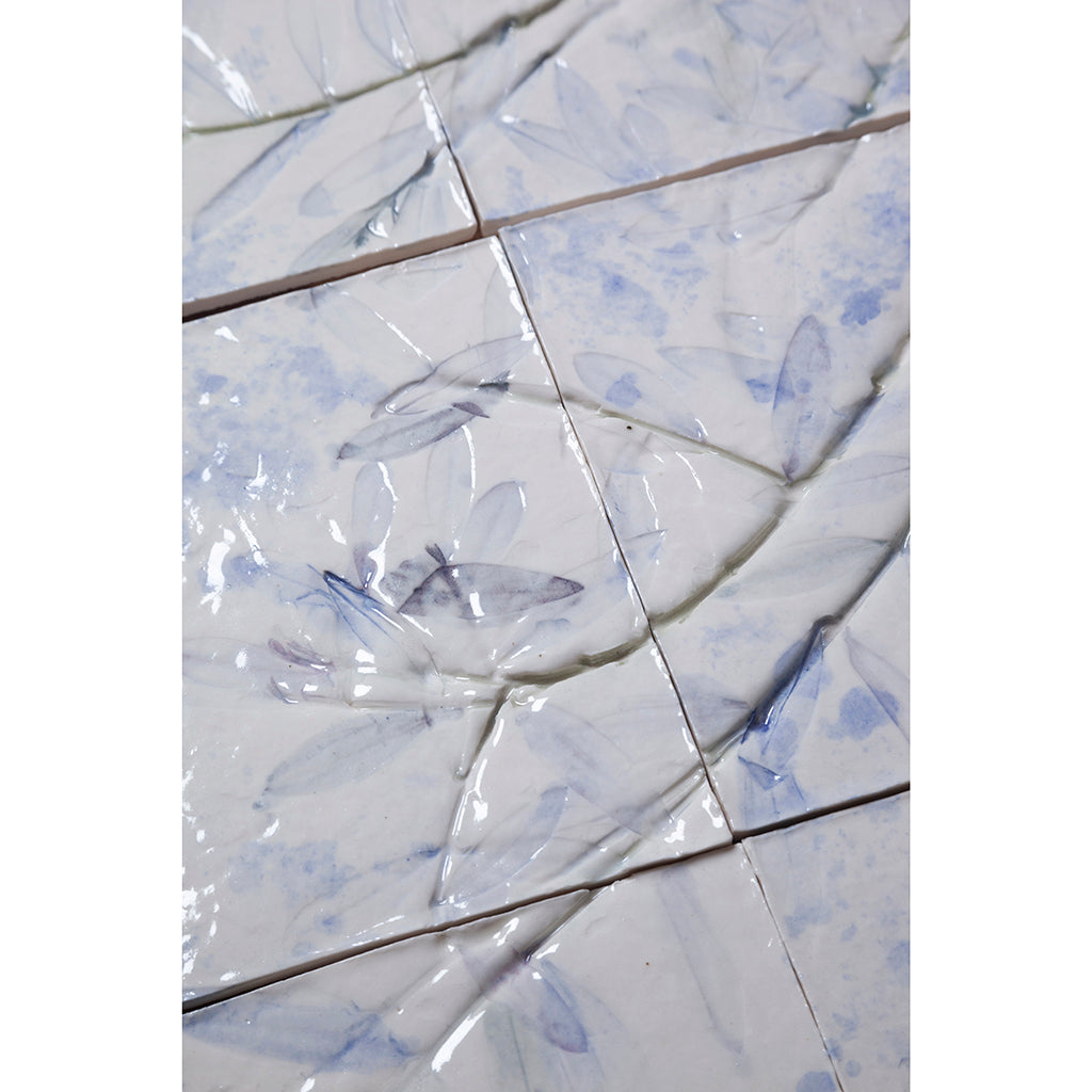 Detail of Large porcelain tile panel of an olive tree. Looking at leaves and branches. Blue and browny green colours on a white background