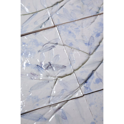 Detail of Large porcelain tile panel of an olive tree. Looking at leaves and branches. Blue and browny green colours on a white background