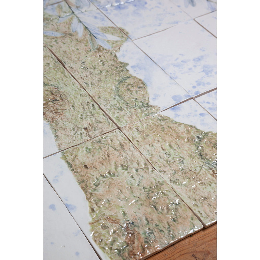 Detail of Large porcelain tile panel of an olive tree. Looking at trunk of tree. Blue, beige and green colors on a white background