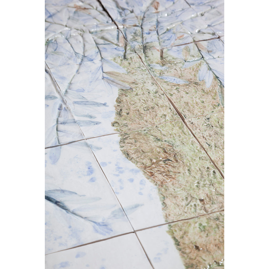 Detail of Large porcelain tile panel of an olive tree. Looking at trunk of tree and some leaves. Blue, beige and green colors on a white background